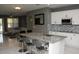 Modern kitchen featuring white cabinets, granite countertops, stainless steel appliances, and an island with seating at 1991 Sanderlin Point Loop, Apopka, FL 32703