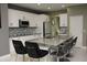 Modern kitchen with white cabinetry, stainless steel appliances, and a large island with granite countertop and seating at 1991 Sanderlin Point Loop, Apopka, FL 32703