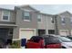 Close-up of a townhouse exterior showing a garage, front door, and neutral gray color scheme at 1026 Lido Dr, Howey In The Hills, FL 34737