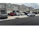 Row of townhouses with gray exteriors, garages, and various cars parked in front, showing curb appeal at 1026 Lido Dr, Howey In The Hills, FL 34737