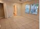 Bedroom featuring tile floors, dual windows, and ensuite bathroom at 7990 Midway Drive Ter # M103, Ocala, FL 34472