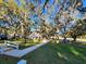 A scenic view of a charming house framed by moss-draped oak trees, overlooking a lush green lawn and community at 7990 Midway Drive Ter # M103, Ocala, FL 34472