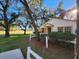 Charming single-story home featuring a lush green lawn, mature trees, and a white picket fence at 7990 Midway Drive Ter # M103, Ocala, FL 34472
