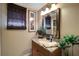 Stylish half bathroom features granite countertop, decorative mirror, and contemporary lighting at 4435 Fairway Oaks Dr, Mulberry, FL 33860