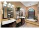 Elegant bathroom with double vanity sinks, decorative shelving, and a soaking tub for relaxation at 4435 Fairway Oaks Dr, Mulberry, FL 33860
