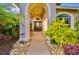 Inviting front entryway with a gorgeous stone walkway, lush landscaping, and decorative plants at 4435 Fairway Oaks Dr, Mulberry, FL 33860