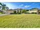 Beautiful single-story home with a luscious lawn, palm trees and immaculate landscaping at 4435 Fairway Oaks Dr, Mulberry, FL 33860