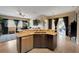 Modern kitchen island featuring granite countertops and stainless steel dishwasher, adjoining a bright living space at 4435 Fairway Oaks Dr, Mulberry, FL 33860