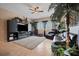 Comfortable living room featuring a large TV, fireplace, and lush indoor plants for a cozy atmosphere at 4435 Fairway Oaks Dr, Mulberry, FL 33860