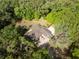 Aerial view shows the home nestled among lush trees with a circular brick driveway at 445 Se 98Th Ave, Webster, FL 33597