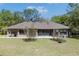Backyard view of the house showing the patio, landscaping, and large backyard at 445 Se 98Th Ave, Webster, FL 33597