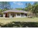 Backyard view of the house showing the patio, landscaping, and large backyard at 445 Se 98Th Ave, Webster, FL 33597