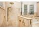 Luxurious bathroom showcasing a tiled shower, gold fixtures, and a relaxing bathtub with windows at 445 Se 98Th Ave, Webster, FL 33597