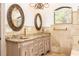 Elegant bathroom featuring double sinks, granite countertops, and decorative oval mirrors at 445 Se 98Th Ave, Webster, FL 33597