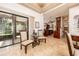 Open-concept dining area features travertine tile flooring, glass table, and sliding glass doors to the lanai at 445 Se 98Th Ave, Webster, FL 33597