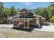 Exterior view of the home showcasing the balcony, garage, and brick-paved carport at 445 Se 98Th Ave, Webster, FL 33597