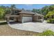 Side exterior view showing the garage with a paved driveway and a second story balcony at 445 Se 98Th Ave, Webster, FL 33597