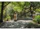 A wrought iron gate between two stone pillars marks the entrance to the estate at 445 Se 98Th Ave, Webster, FL 33597