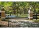 View of the gated entrance with mature landscaping and an ADT security sign at 445 Se 98Th Ave, Webster, FL 33597