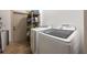 Laundry room includes newer front-loading washer and dryer, shelving, and convenient tiled flooring at 445 Se 98Th Ave, Webster, FL 33597