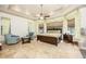 Inviting main bedroom with tray ceiling, fan, sitting area, and large windows with decorative draperies at 445 Se 98Th Ave, Webster, FL 33597
