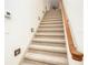 Carpeted staircase with wooden handrail and ambient lighting, providing a safe and stylish transition between floors at 445 Se 98Th Ave, Webster, FL 33597