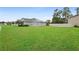 Expansive backyard featuring a lush green lawn, privacy fence, and partial view of the home at 805 Baylor Dr, Deltona, FL 32725