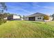 Spacious backyard view showing the exterior of the home and the screened in patio at 805 Baylor Dr, Deltona, FL 32725