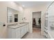 Bathroom featuring double sinks with granite counters and a view into the large walk-in closet at 805 Baylor Dr, Deltona, FL 32725