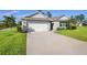 Single-story home showcasing a driveway, two-car garage, complemented by vibrant green lawn at 805 Baylor Dr, Deltona, FL 32725