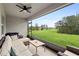 Relaxing screened porch with comfortable seating and a ceiling fan overlooking a well-maintained lawn at 805 Baylor Dr, Deltona, FL 32725