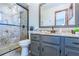 Bathroom featuring a walk-in shower, gray vanity and updated fixtures at 568 Gainsboro St, Deltona, FL 32725