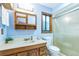 Bathroom featuring vintage cabinets, a large mirror, and a glass-enclosed shower at 568 Gainsboro St, Deltona, FL 32725