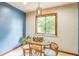 Cozy dining area with a glass table, wicker chairs, and natural light from the window at 568 Gainsboro St, Deltona, FL 32725
