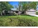 Inviting single-story home with a lush green lawn, mature trees, and a well-manicured landscape at 568 Gainsboro St, Deltona, FL 32725