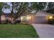 Charming single-story home with a well-maintained lawn, mature trees, and welcoming curb appeal at dusk at 568 Gainsboro St, Deltona, FL 32725