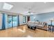 Bright living room with skylights, hardwood floors, and a sliding glass door that opens to the pool area at 568 Gainsboro St, Deltona, FL 32725