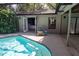 Backyard with covered pool, chair and open access to a bedroom and the indoors at 568 Gainsboro St, Deltona, FL 32725