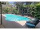 Backyard view of a gorgeous pool surrounded by tropical landscape and full screening at 568 Gainsboro St, Deltona, FL 32725