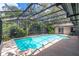 The home's sparkling pool is protected by a full screen enclosure and mature landscaping at 568 Gainsboro St, Deltona, FL 32725