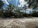 Peaceful single Gathering home nestled amongst mature trees with a gravel driveway and black SUV at 9124 Sw 158Th Ln, Dunnellon, FL 34432