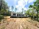 New home exterior, showing grey siding, black shutters, and an unfinished front yard at 9124 Sw 158Th Ln, Dunnellon, FL 34432