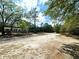 Land with home exterior, large dirt driveway, and mature trees at 9124 Sw 158Th Ln, Dunnellon, FL 34432