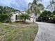Well-maintained home with an attached two-car garage, complemented by lush landscaping and mature palm trees at 12113 Calaboose Ct, Orlando, FL 32828