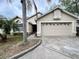 Charming single-story home boasts a two-car garage and is complemented by tropical landscaping and a well-manicured lawn at 12113 Calaboose Ct, Orlando, FL 32828