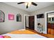 Cozy bedroom with a view into the ensuite bathroom with dark-stained trim, hardwood floors and a decorative mirror at 501 Washington Ave, Eustis, FL 32726