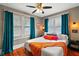 Bright bedroom featuring hardwood floors, ceiling fan and colorful decor with natural light from the windows at 501 Washington Ave, Eustis, FL 32726