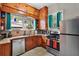 Rustic kitchen with wood cabinetry, stainless steel appliances, tiled backsplash, and ample natural light at 501 Washington Ave, Eustis, FL 32726