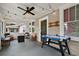 Inviting front porch with an air hockey table, seating, fire pit, ceiling fan, and string lights at 501 Washington Ave, Eustis, FL 32726