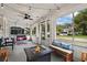 Enclosed porch with a fire pit, string lights, swing bench, ceiling fan and plenty of natural light at 501 Washington Ave, Eustis, FL 32726